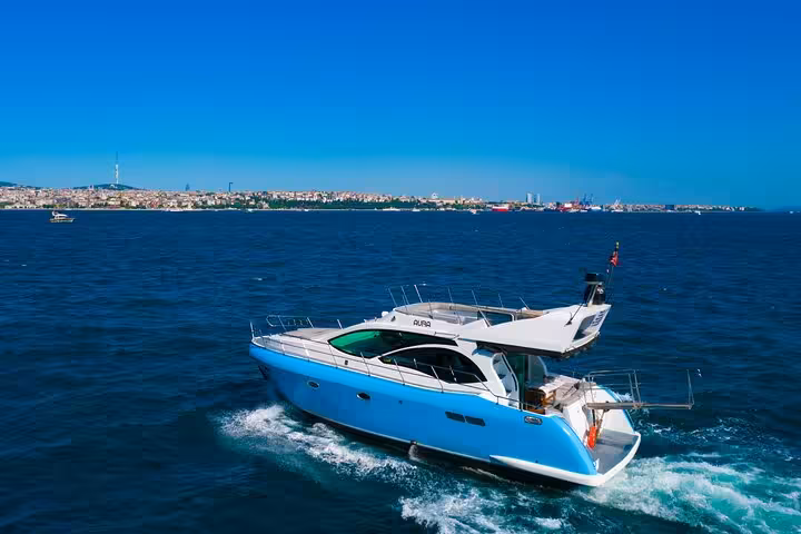 Luxury motor yacht on a private Istanbul Bosphorus cruise, speeding across the strait with skyline views