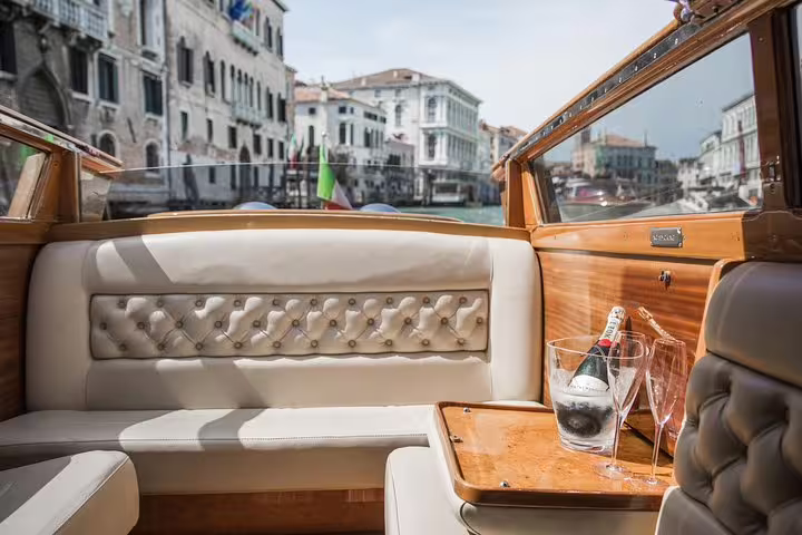 Luxurious LimoBoat interior with champagne, cruising through Venice canals, perfect for Murano, Burano, and Torcello tours.