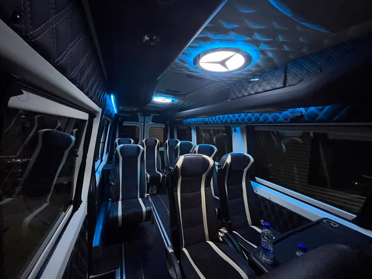 Luxury Mercedes minibus interior with blue ambient lighting and black leather seats for private Iceland transfer