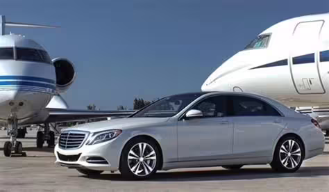 Luxury Mercedes sedan parked by private jets, illustrating premium Naples to Paestum airport transfer service