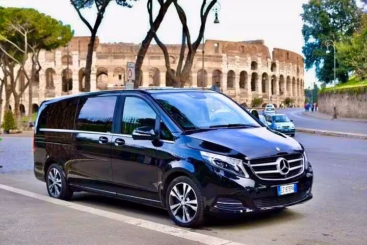 Luxury black Mercedes van for private chauffeured Rome tour parked by the Colosseum and ancient Roman landmarks