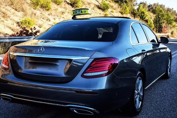 Luxury black Mercedes-Benz sedan taxi on highway for private transfer service