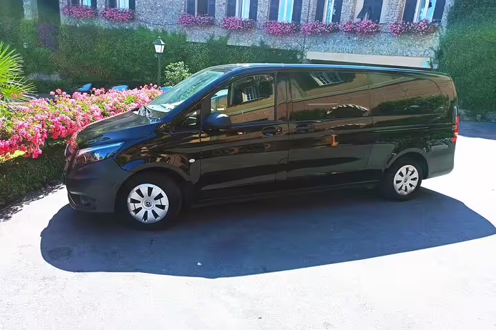 Black luxury minivan for private chauffeur transfer to The Mall and Prada Space Outlet, ready for a full‑day shopping tour