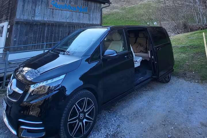 Luxury black minivan for private transfer from Luzern to Zurich, spacious interior and door open for pickup