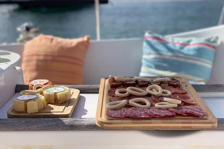Delight in a luxurious private sailing cruise with gourmet charcuterie and cheese platters against a serene ocean backdrop.
