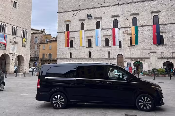 Luxury black van parked in historic Italian square, offering private transfer from Bologna Airport to Florence.
