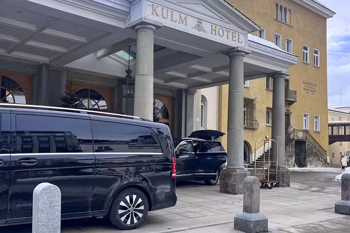 Luxury vehicle parked outside the entrance of a hotel in St. Moritz, ready for private transfer from Milan.