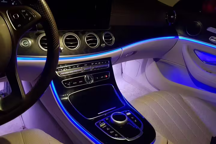 Luxury car interior with ambient blue lighting for comfortable private airport transfer in Valencia Spain