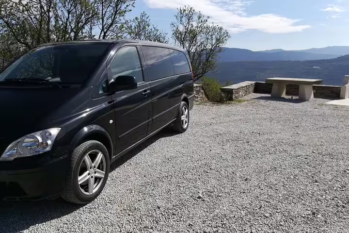 Luxury private van ready for a scenic Douro Valley tour from Porto, parked with a stunning mountain view backdrop.