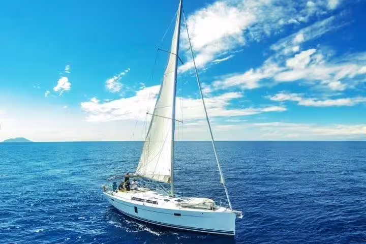 Luxurious sailing yacht gliding on crystal blue waters under a sunny sky, ideal for private charter experiences.