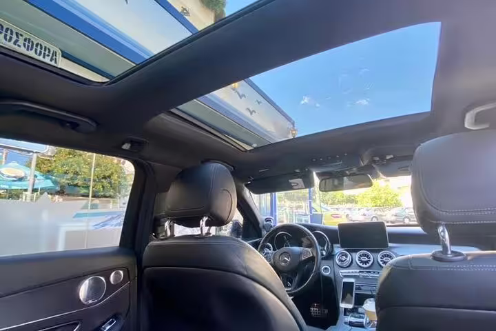 Luxury sedan interior with panoramic sunroof, ideal for private airport pickup and chauffeured transfer service