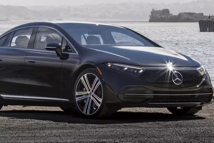 Luxury sedan parked by the waterfront, showcasing premium comfort for the Lisbon to Seville private journey direct route.