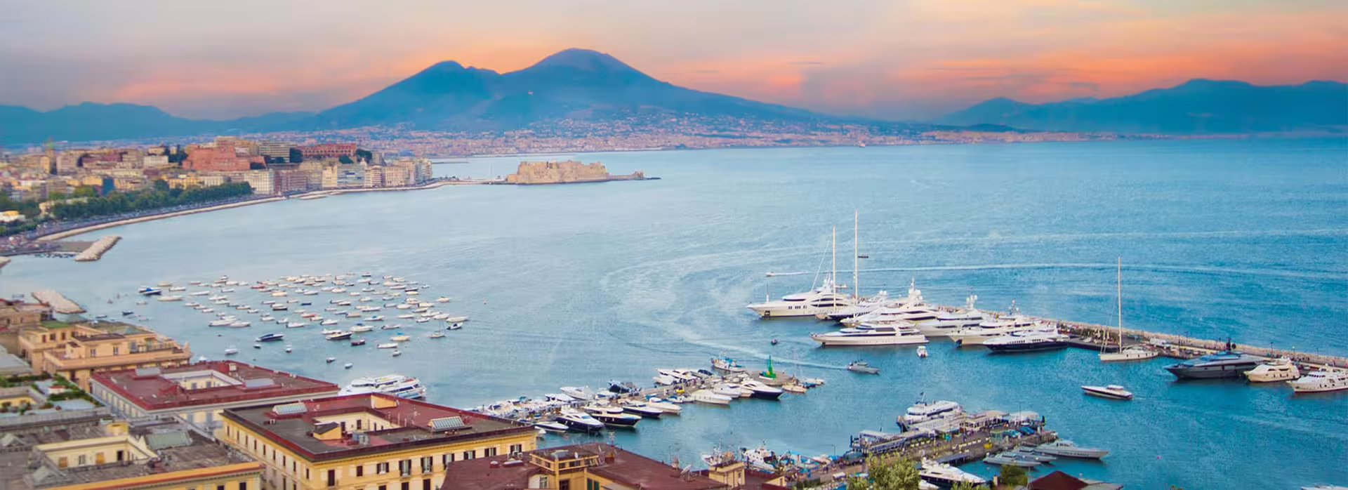 Professional chauffeur opens luxury sedan door for private transfer from Naples to Rome with door-to-door service