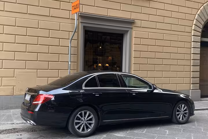 Black luxury sedan at a taxi stand in Rome, perfect for a seamless private transfer to Fiumicino Airport.