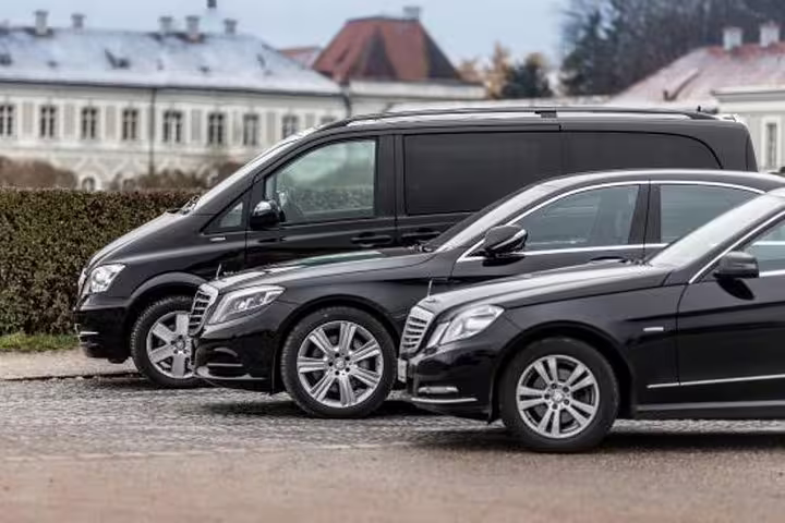 Line of black luxury sedans and minivans offering premium private transfer options on the Praiano to Naples route