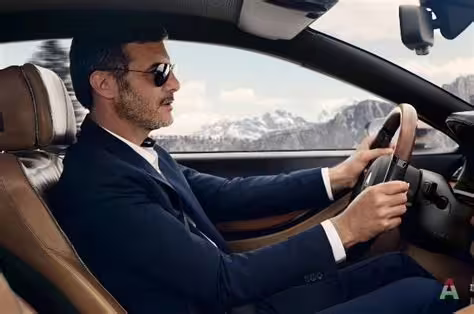 Professional chauffeur driving luxury sedan on scenic route between Naples and Pozzuoli with mountain views outside