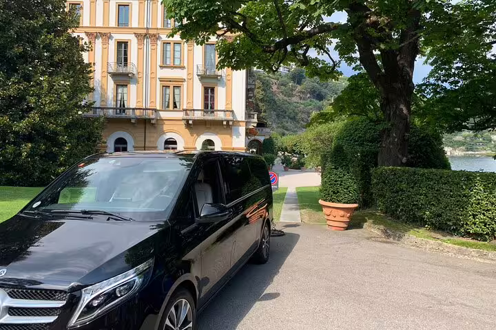 Luxury van parked in front of a grand villa, perfect for a full-day private tour in Lake Como.