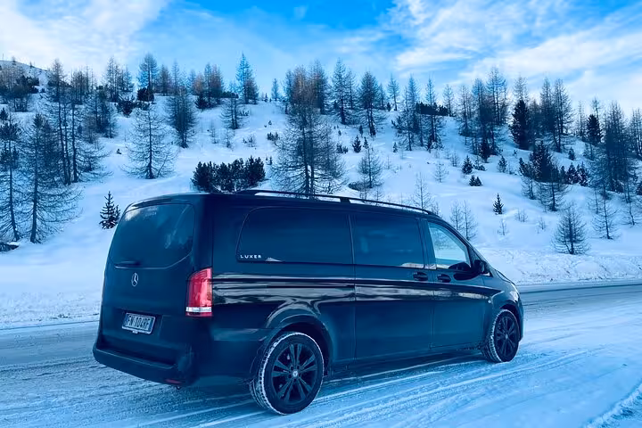 Luxury van on a snowy road through scenic winter landscapes en route from Venice to Cortina d'Ampezzo.