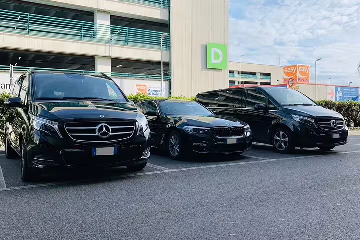 Three black luxury vehicles parked at Roatan Airport RTB offering private transfer service to Roatan hotels