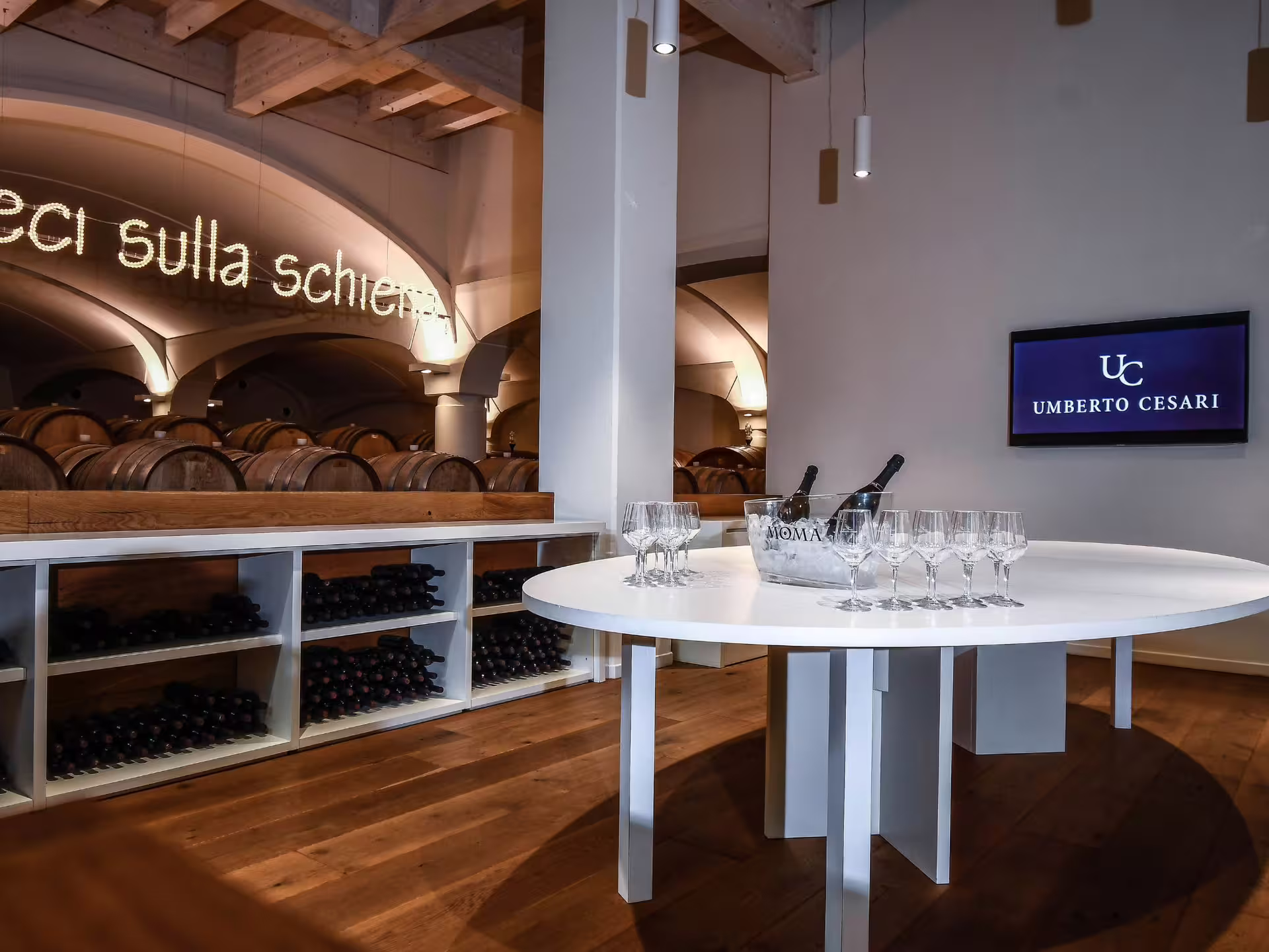 Elegant wine tasting room with oak barrels and wine glasses near Bologna, perfect for a food and wine pairing experience.