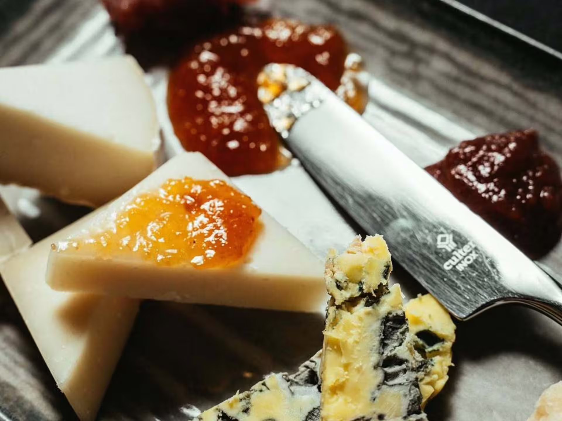 Cheese board with fig jam and knife, gourmet pairing for luxury wine tasting tour in Modena city center