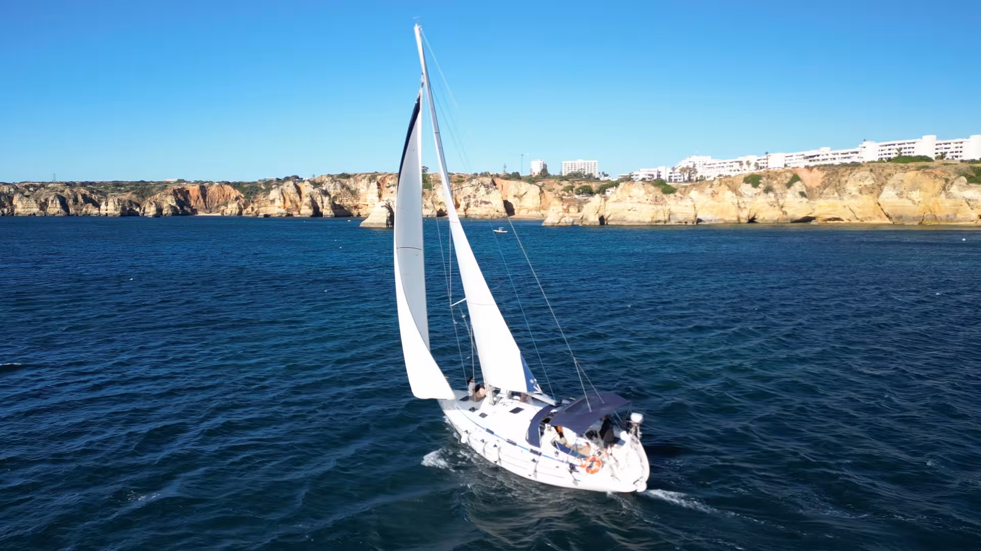 Luxury yacht cruise in Lagos at sunrise, sailing past Algarve cliffs on the Atlantic with ocean views