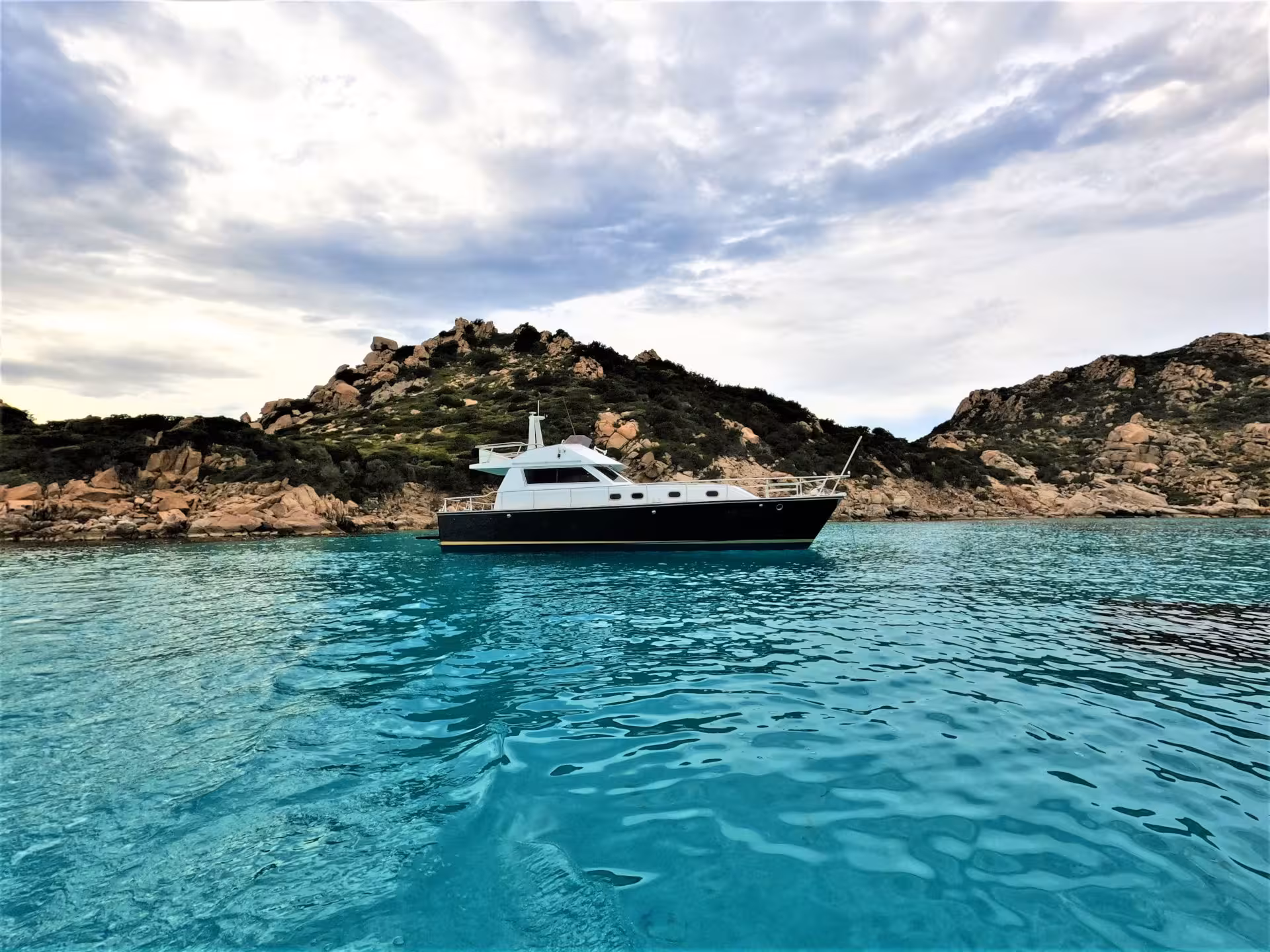 Luxury yacht cruising in the serene turquoise waters of La Maddalena Archipelago, perfect for Palau tours.