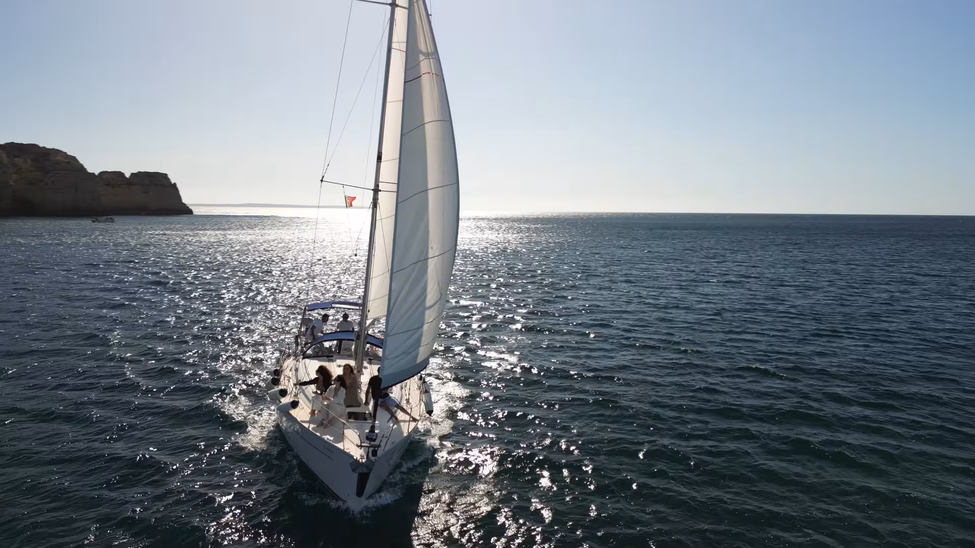 Luxury yacht sailing at sunrise off Lagos, Algarve coast, sparkling Atlantic sea on private morning cruise