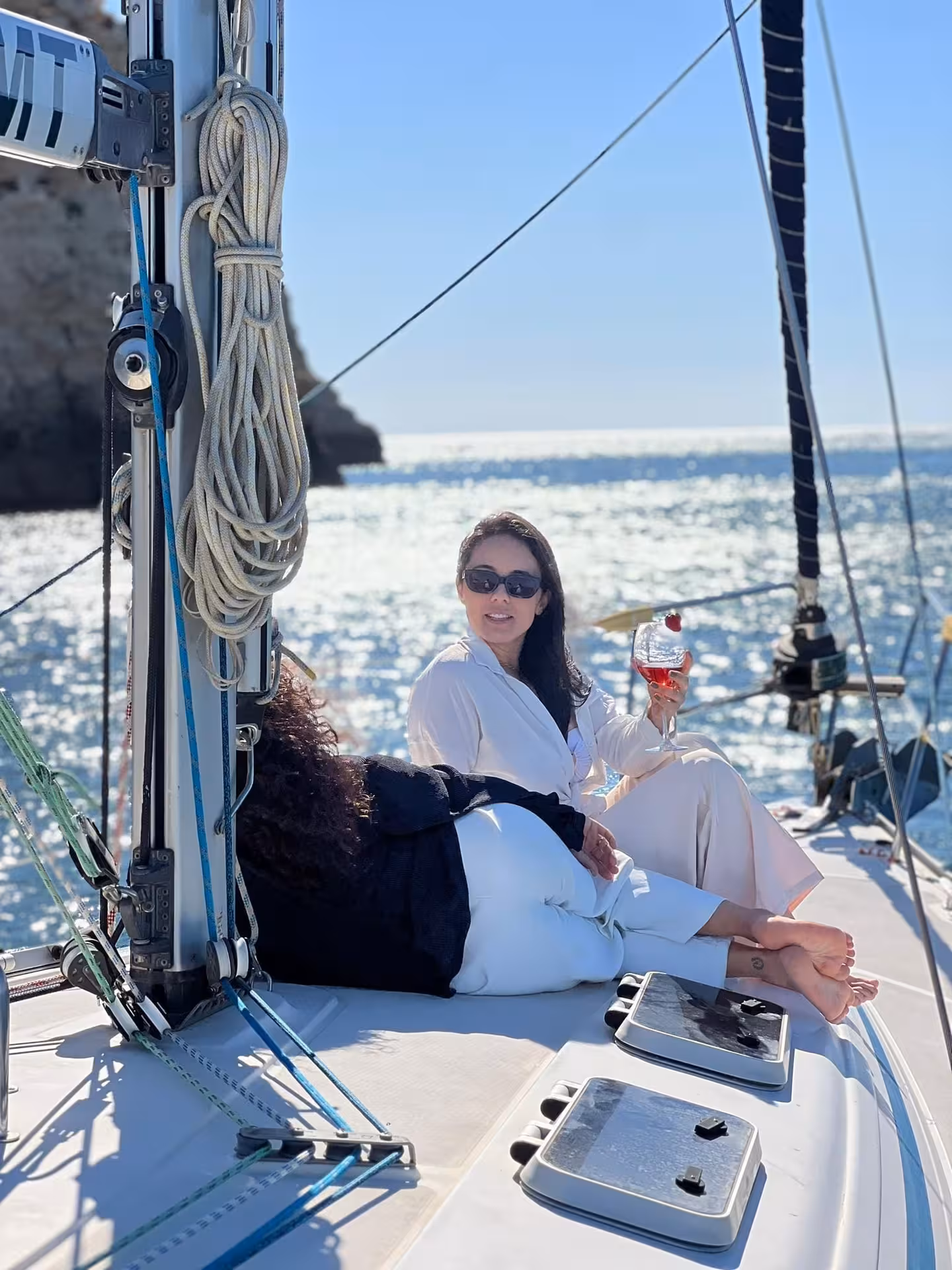 Guests relaxing on luxury yacht deck with drinks near Lagos, Algarve, ideal for romantic golden hour sunset cruise