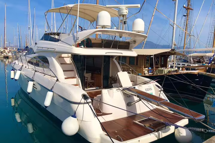 Sleek luxury yacht docked in a marina, offering a perfect setting for sunset wine tasting and gourmet dining.