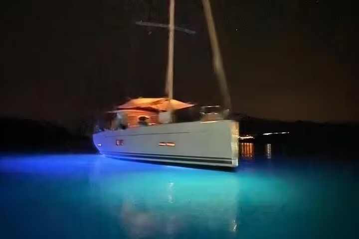 Elegant yacht with glowing blue underwater lights, ideal for a serene evening wine tasting on the water.
