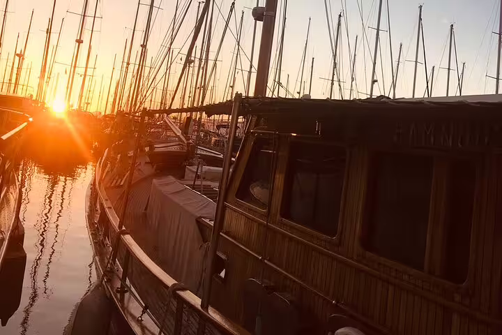 Serene marina at sunset with yachts silhouetted against the glowing horizon, ideal for a luxury wine and dining cruise.