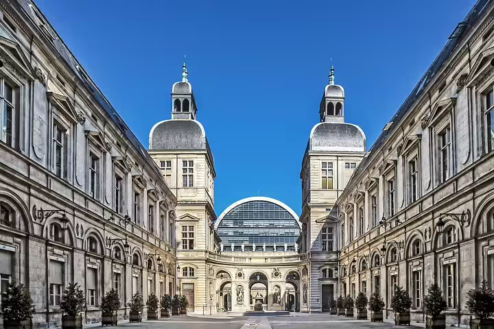 Grand classical courtyard with twin domed towers and glass rotunda in Lyon city center