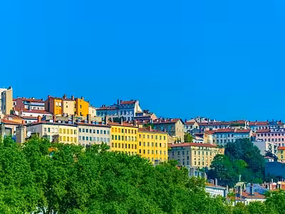 Colorful buildings of Croix-Rousse hillside neighborhood in Lyon under a bright blue sky