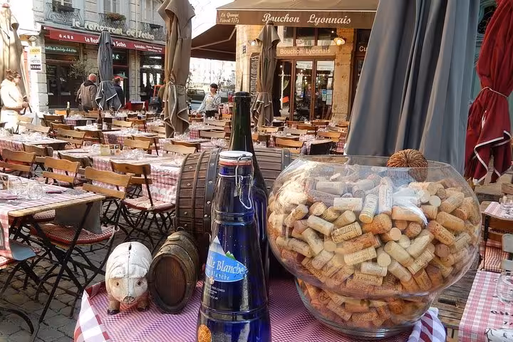 Charming Lyonnais café terrace with wine corks and bottles, showcasing authentic dining on a private food tour.