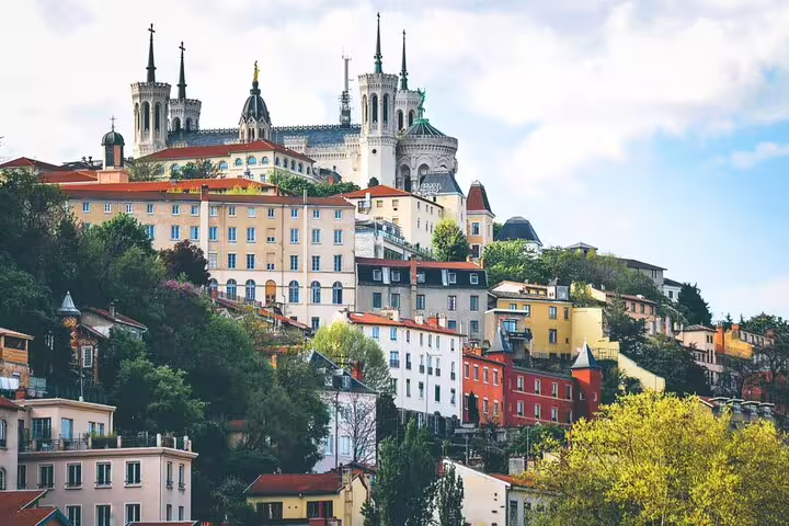 Colorful historic buildings and Fourvière Basilica on the hillside of Lyon Old Town