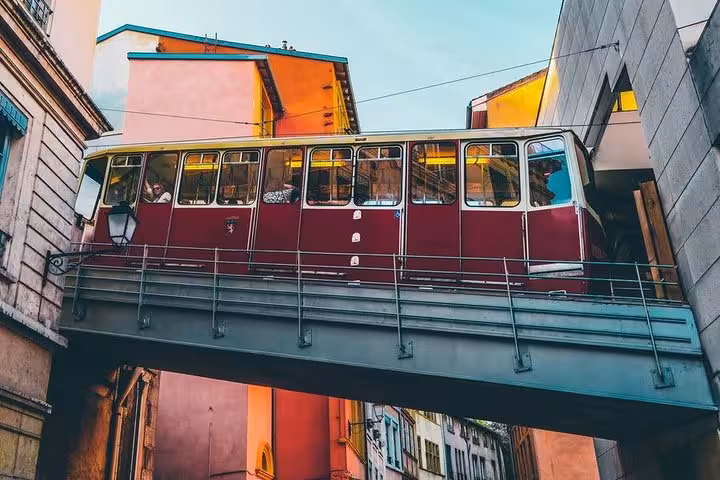 Historic funicular in Lyon's Old Town, framed by colorful buildings, offering a scenic ride on the food tour.