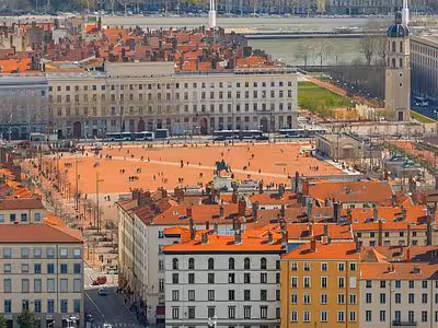 Aerial view of Place Bellecour square in Lyon with orange rooftops and Rhône River in background