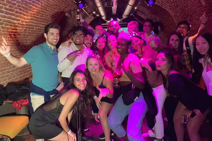 A lively group enjoys the vibrant nightlife in Madrid during a Mad Party Crew pub crawl, showcasing fun and camaraderie.