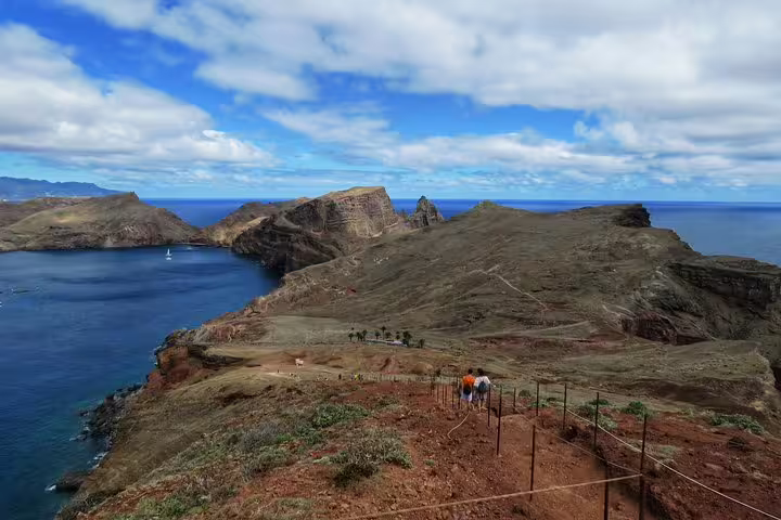 Scenic view of Madeira coastline with hikers on a trail, perfect for 4x4 rides, hiking, swimming, and boat trips.