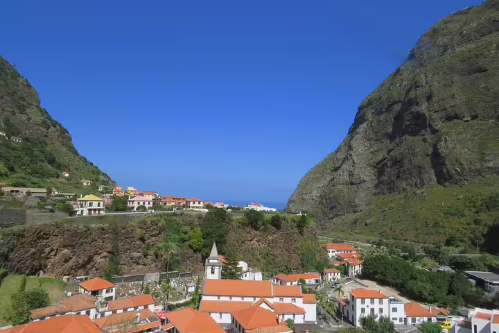 Scenic view of Madeira's Cabo Girão cliffs and charming village, ideal for wine and jeep safari tours exploring island treasures.