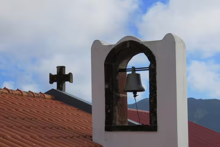 Historic church bell tower against a scenic backdrop in Madeira Islands, capturing cultural charm on a full day guided tour.