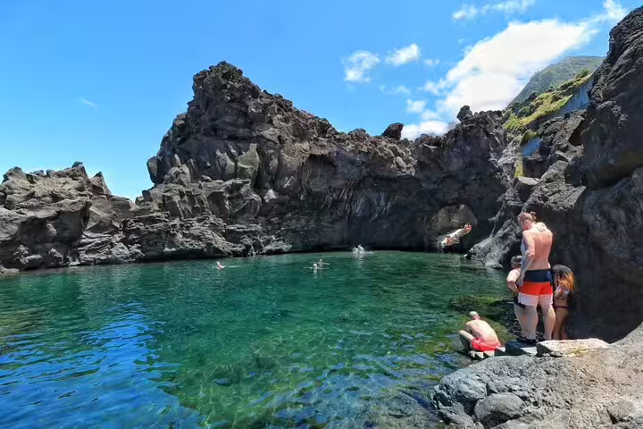 Adventurers enjoy swimming in a stunning volcanic rock pool during a 4x4 tour exploring Madeira's northwest frontiers.