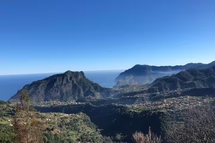 Breathtaking view of Madeira's eastern mountains and lush valleys under a clear blue sky, ideal for a safari tour.