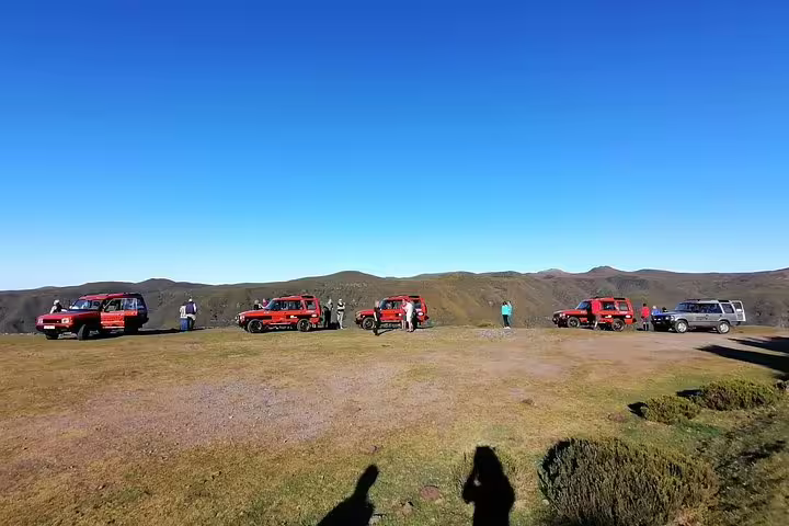 Tourists and red Land Rovers enjoying panoramic views on a Madeira safari adventure in the island's west.