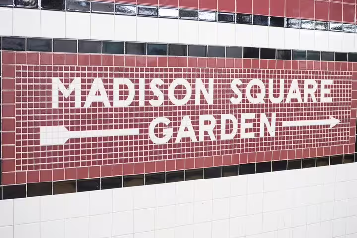 Madison Square Garden subway station tile sign with directional arrows in New York City