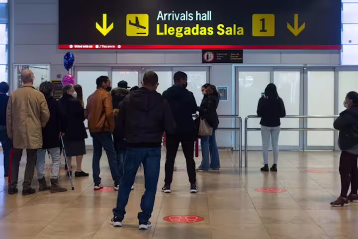 Passengers waiting at Madrid Airport arrivals hall for prebooked private transportation to MAD with hotel pickup