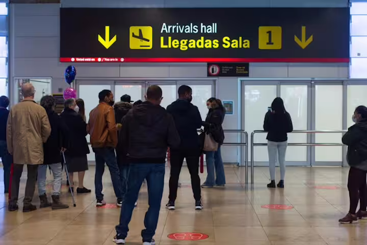 Travelers waiting at Madrid Barajas Airport arrivals hall for private transfer to Madrid city center