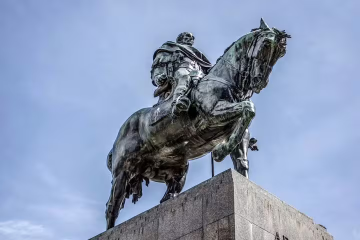Bronze equestrian statue of a rider on a rearing horse on a stone pedestal in Madrid