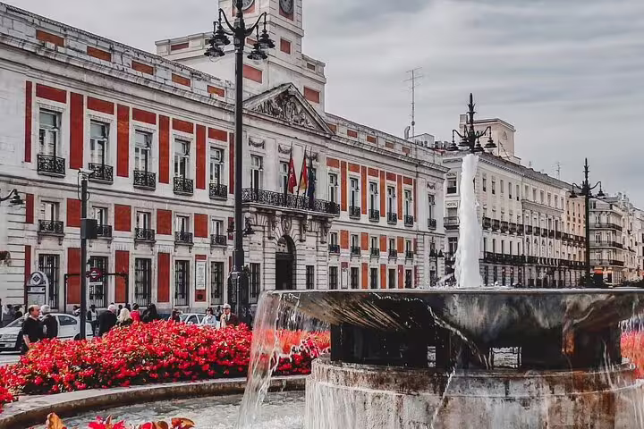 Puerta del Sol fountain and historic red facade building in Madrid city center